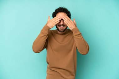 Genç sakallı adam gülümsüyor ve mutlu hissediyor, iki eliyle gözlerini kapatıyor ve inanılmaz bir sürpriz bekliyor.