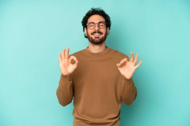 Genç sakallı adam konsantre olmuş ve meditasyon yapıyor, kendini tatmin olmuş ve rahatlamış hissediyor, düşünüyor ya da bir seçim yapıyor.