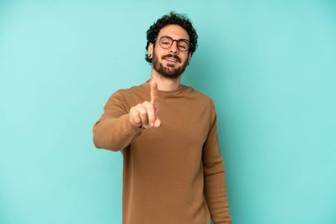 Genç sakallı adam gururla gülümsüyor ve gururla bir numaralı pozu veriyor, kendini lider gibi hissediyor.