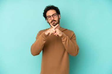 Genç sakallı adam ciddi görünüyor ve iki parmağının önde olması hoşnutsuzluk yaratıyor. Sessizlik istiyor.