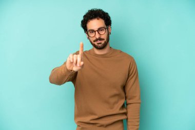 Genç sakallı adam gülümsüyor ve arkadaş canlısı görünüyor, bir numara ya da ilk eli önde, geriye doğru sayıyor.