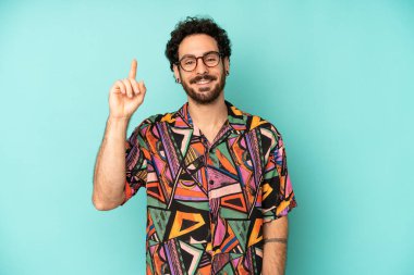 Genç sakallı adam mutlu bir şekilde gülümsüyor, tek eliyle uzayı işaret ediyor.