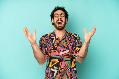 Genç sakallı adam öfkeyle bağırıyor, stresli hissediyor ve ellerini havaya kaldırıp neden ben diye bağırıyor.