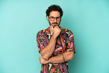 Genç sakallı adam ciddi görünüyor, kafası karışık, kararsız ve düşünceli, seçenekler ve seçimler arasında şüpheci.