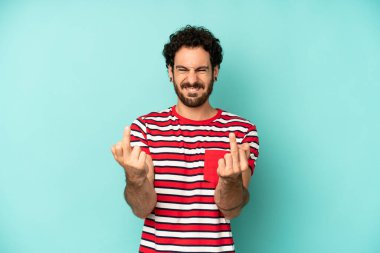 Genç sakallı adam kışkırtıcı, agresif ve müstehcen hissediyor. İsyankar bir tavırla orta parmağını hareket ettiriyor.