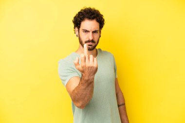 Genç sakallı adam kızgın, sinirli, asi ve agresif hissediyor, orta parmağını hareket ettiriyor, karşı koyuyor.