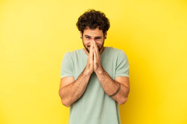 Genç sakallı adam endişeli, umutlu ve dindar hissediyor. Avuçlarına bastırılmış, af dileyen sadık bir şekilde dua ediyor.