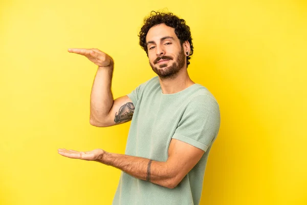 Joven Barbudo Sonriendo Sintiéndose Feliz Positivo Satisfecho Sosteniendo Mostrando Objeto —  Fotos de Stock