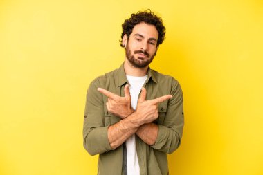 Genç sakallı adam şaşkın ve şaşkın görünüyor, güvensiz ve zıt yönlere şüpheyle bakıyor.