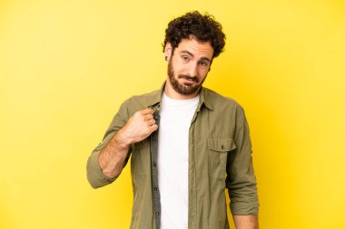 Genç sakallı adam kibirli, başarılı, pozitif ve gururlu görünüyor.