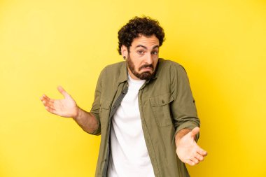 young bearded man feeling clueless and confused, having no idea, absolutely puzzled with a dumb or foolish look