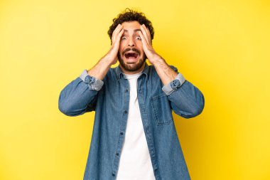 Genç sakallı adam el ele tutuşuyor, ağzı açık, son derece şanslı, şaşırmış, heyecanlı ve mutlu hissediyor.