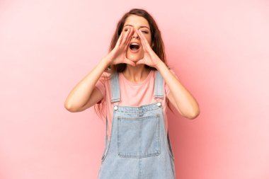 Genç ve güzel bir kadın mutlu, heyecanlı ve pozitif hissediyor. Elleri ağızda, bağırıyor.