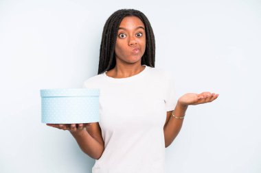 Siyah güzel kadın şaşkın, şaşkın ve şüpheci hissediyor. hediye kutusu konsepti