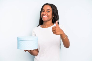 Siyah, güzel bir kadın gururlu, olumlu gülümsüyor. hediye kutusu konsepti