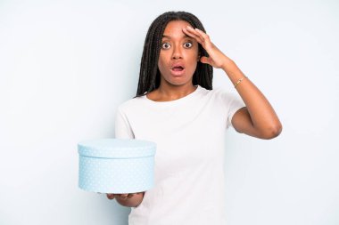 Siyah güzel kadın mutlu, şaşkın ve şaşırmış görünüyor. hediye kutusu konsepti