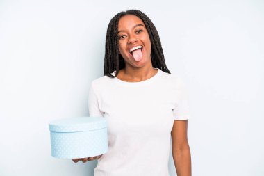 Siyah, güzel, neşeli ve asi tavırlı bir kadın, şaka yapıyor ve dilini dışarı çıkarıyor. hediye kutusu konsepti