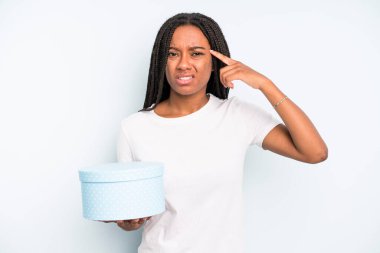 Siyah, güzel bir kadın kafası karışık ve şaşkın hissediyor, deli olduğunu gösteriyor. hediye kutusu konsepti