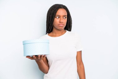 Siyah, güzel bir kadın üzgün, üzgün ya da kızgın hissedip yan tarafa bakıyor. hediye kutusu konsepti