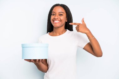 Siyahi, güzel bir kadın, kendine güvenerek gülümsüyor. hediye kutusu konsepti