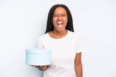 Siyah, güzel bir kadın agresif bir şekilde bağırıyor, çok kızgın görünüyor. hediye kutusu konsepti