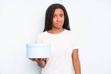 Kafası karışmış ve kafası karışmış siyah güzel bir kadın. hediye kutusu konsepti