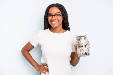 Siyah güzel bir kadın mutlu bir şekilde gülümsüyor, eli kalçasında ve kendinden emin. kaydetme kavramı