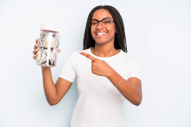 black pretty woman looking excited and surprised pointing to the side. savings concept