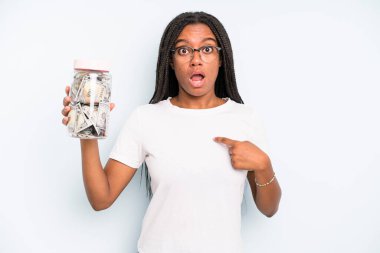 black pretty woman looking shocked and surprised with mouth wide open, pointing to self. savings concept