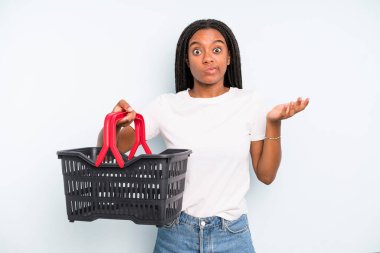 black pretty woman feeling puzzled and confused and doubting. empty shopping basket