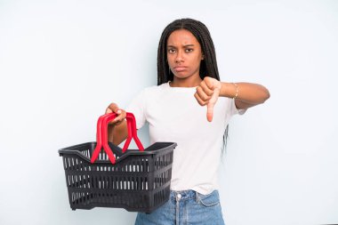 black pretty woman feeling cross,showing thumbs down. empty shopping basket