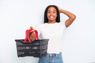 black pretty woman feeling stressed, anxious or scared, with hands on head. empty shopping basket