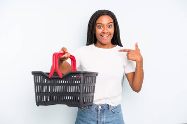 black pretty woman feeling happy and pointing to self with an excited. empty shopping basket