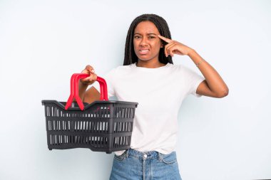 black pretty woman feeling confused and puzzled, showing you are insane. empty shopping basket