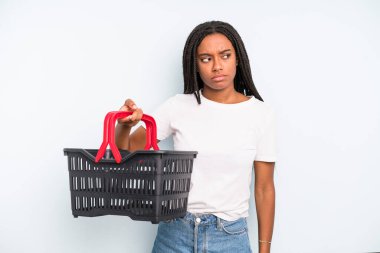 black pretty woman feeling sad, upset or angry and looking to the side. empty shopping basket