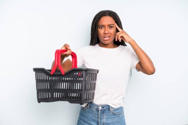 black pretty woman looking surprised, realizing a new thought, idea or concept. empty shopping basket