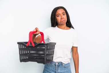 black pretty woman feeling sad and whiney with an unhappy look and crying. empty shopping basket