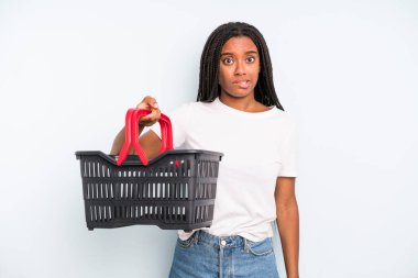 black pretty woman looking puzzled and confused. empty shopping basket