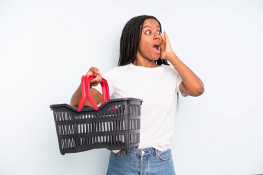 black pretty woman feeling happy, excited and surprised. empty shopping basket