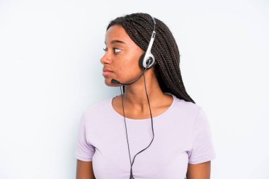 black pretty woman on profile view thinking, imagining or daydreaming. telemarketer concept