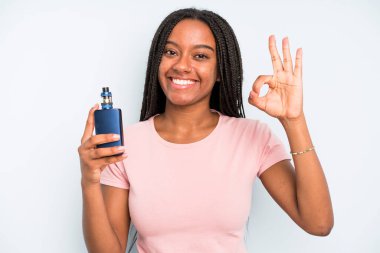 black pretty woman feeling happy, showing approval with okay gesture. smoker vaper concept
