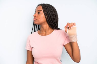 black pretty woman on profile view thinking, imagining or daydreaming. broken hand concept