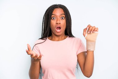 black pretty woman feeling extremely shocked and surprised. broken hand concept