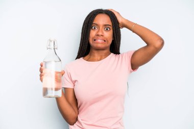 black pretty woman feeling stressed, anxious or scared, with hands on head. water bottle concept