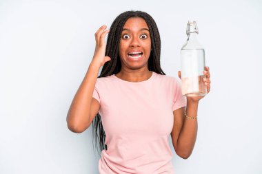 black pretty woman screaming with hands up in the air. water bottle concept