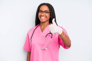 black pretty woman feeling proud,smiling positively with thumbs up. nurse concept
