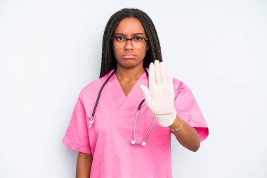 black pretty woman looking serious showing open palm making stop gesture. nurse concept