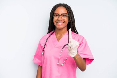 black pretty woman smiling proudly and confidently making number one. nurse concept