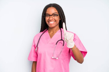 black pretty woman smiling and looking friendly, showing number one. nurse concept