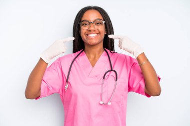 black pretty woman smiling confidently pointing to own broad smile. nurse concept